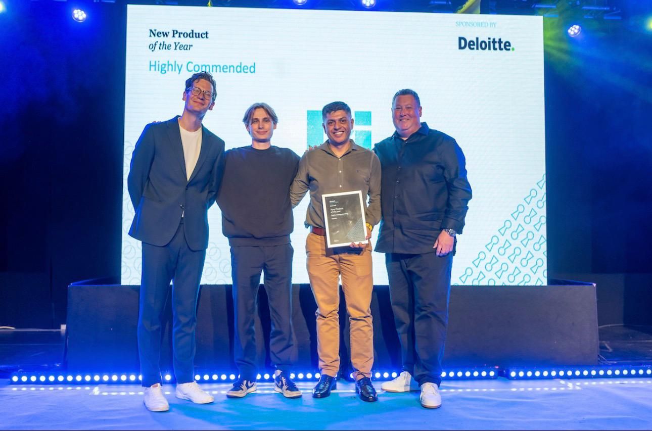 Amir Javed holding the Highly Commended award for New Product of the Year, on stage with three colleagues at the FinTech Awards Wales 2025